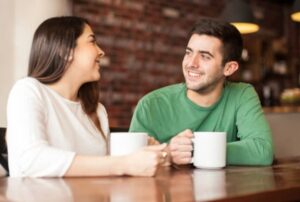 A young woman and man smiling at each other on a date